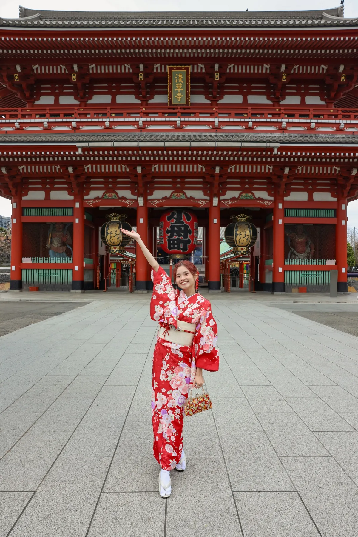 Wingkeh wearing a red kimono in front of a Japanese temple